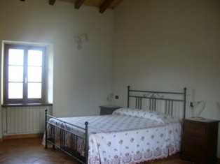 Ampia camera da letto dotata di letto matrimoniale e/o singolo, contraddistinta da travi e tetto in legno a vista. Clicca per ingrandirla